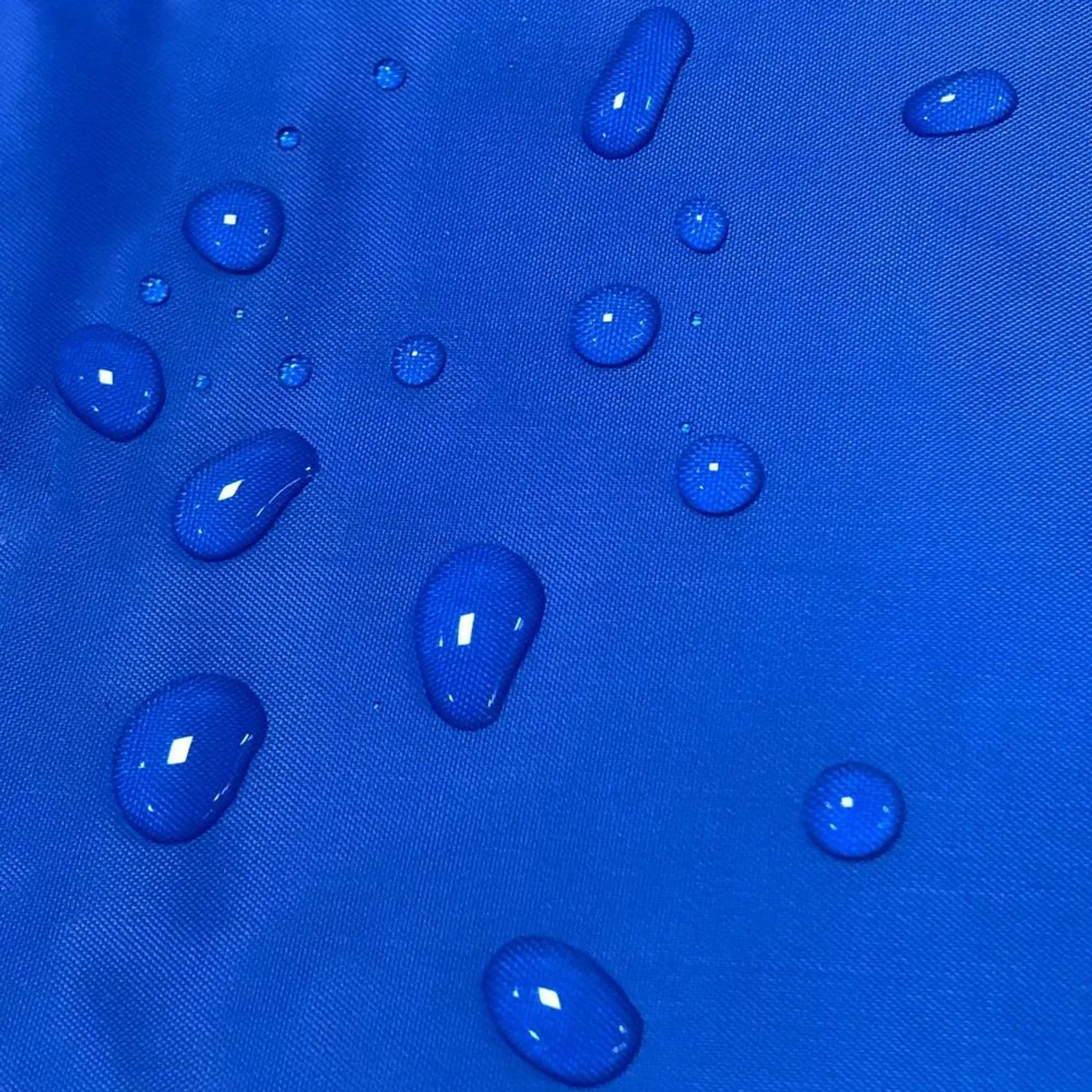Wassertropfen auf blauem Stoff.