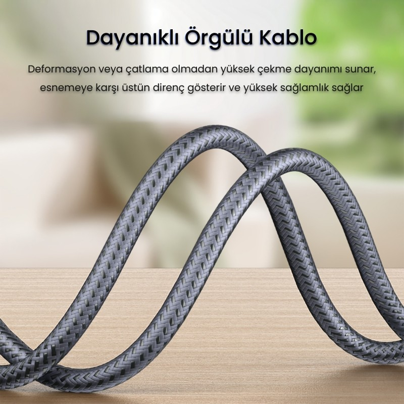 Ahşap bir yüzeyde duran gri örgülü kablo. Arka plan bulanık.