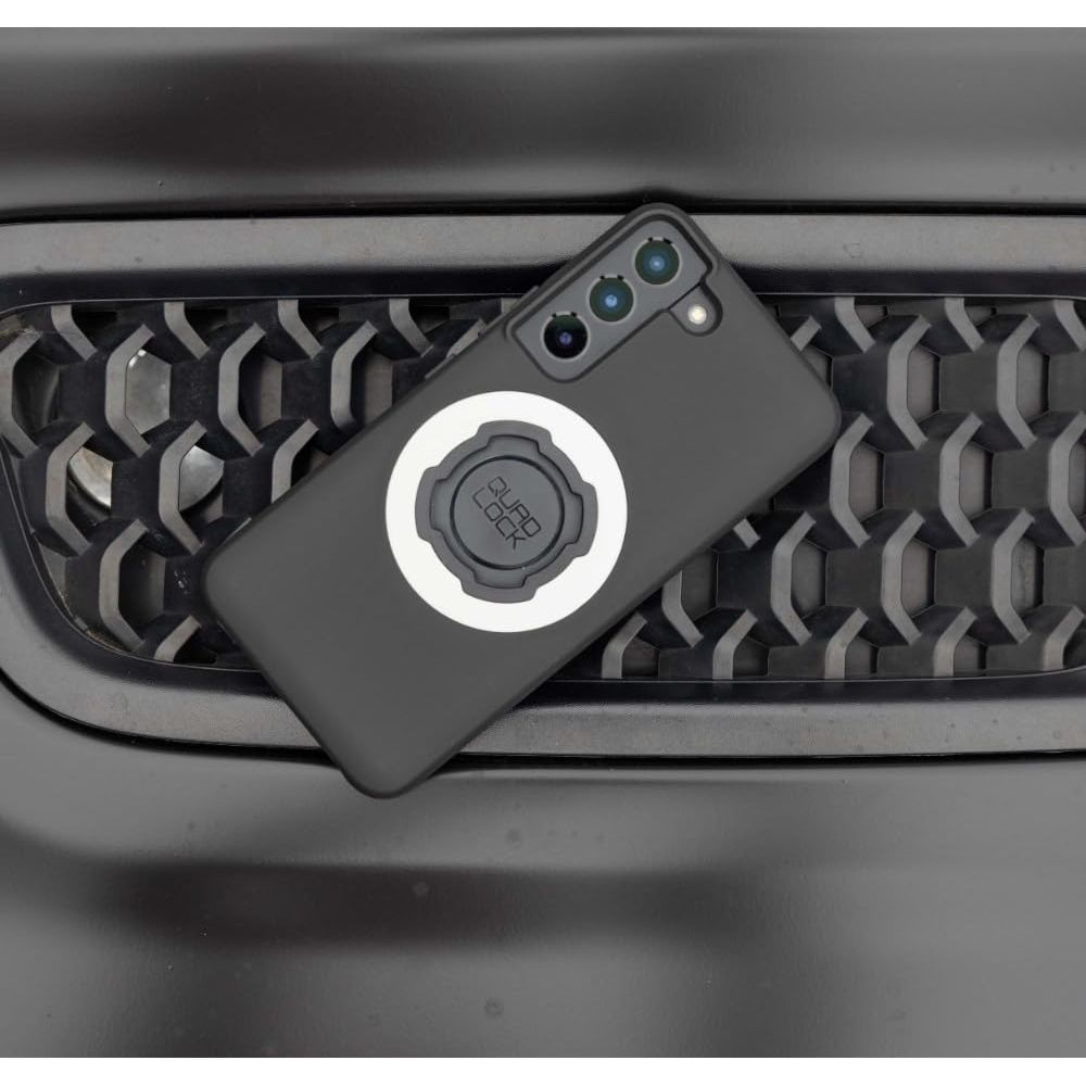 Un telefono nero con supporto Quad Lock poggia su una griglia nera.