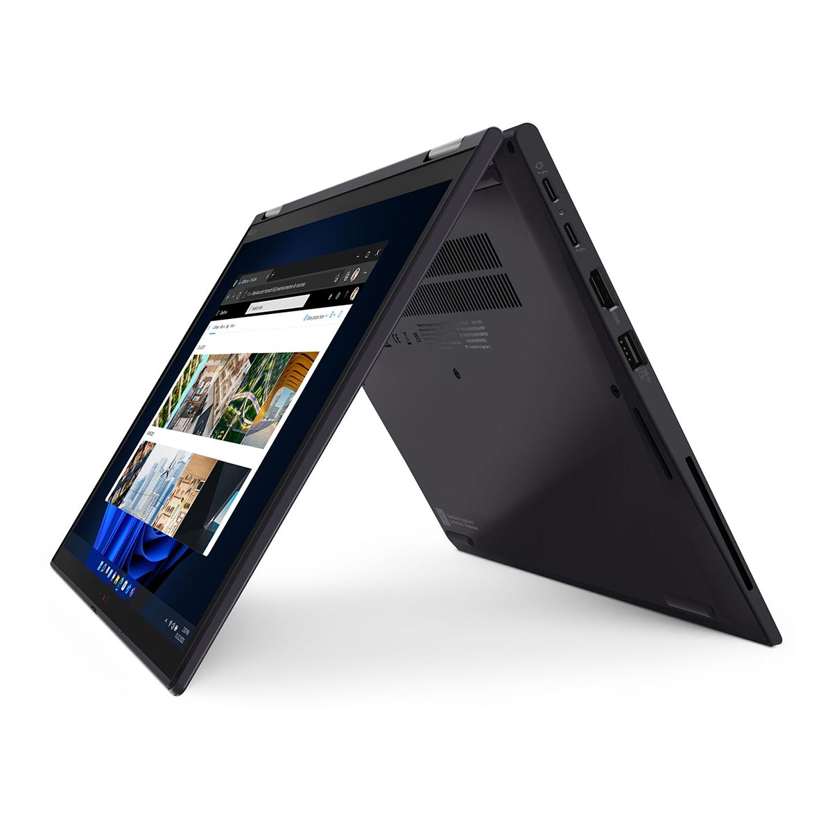 Ciemny laptop jest otwarty, wyświetla obrazy na ekranie.