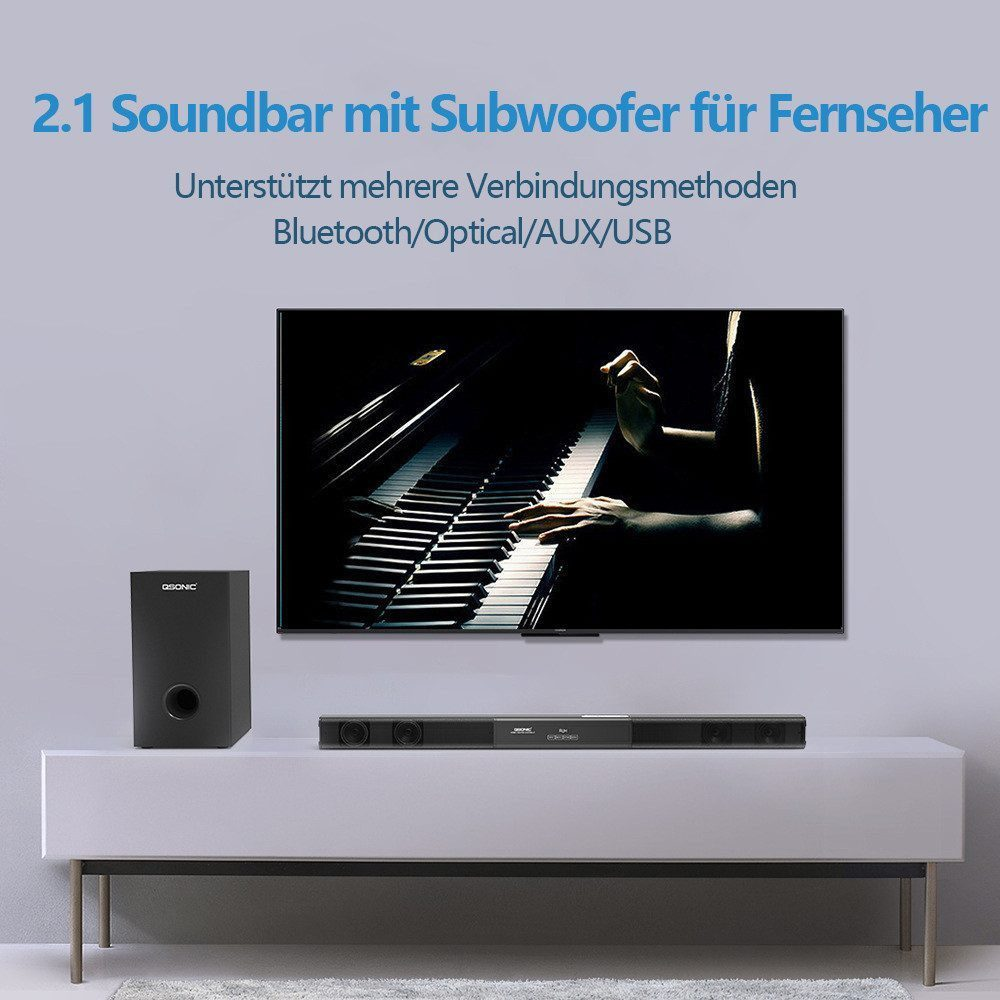 Ein schwarzer Subwoofer und eine Soundbar stehen auf einem weißen Schrank, davor ein Fernseher.