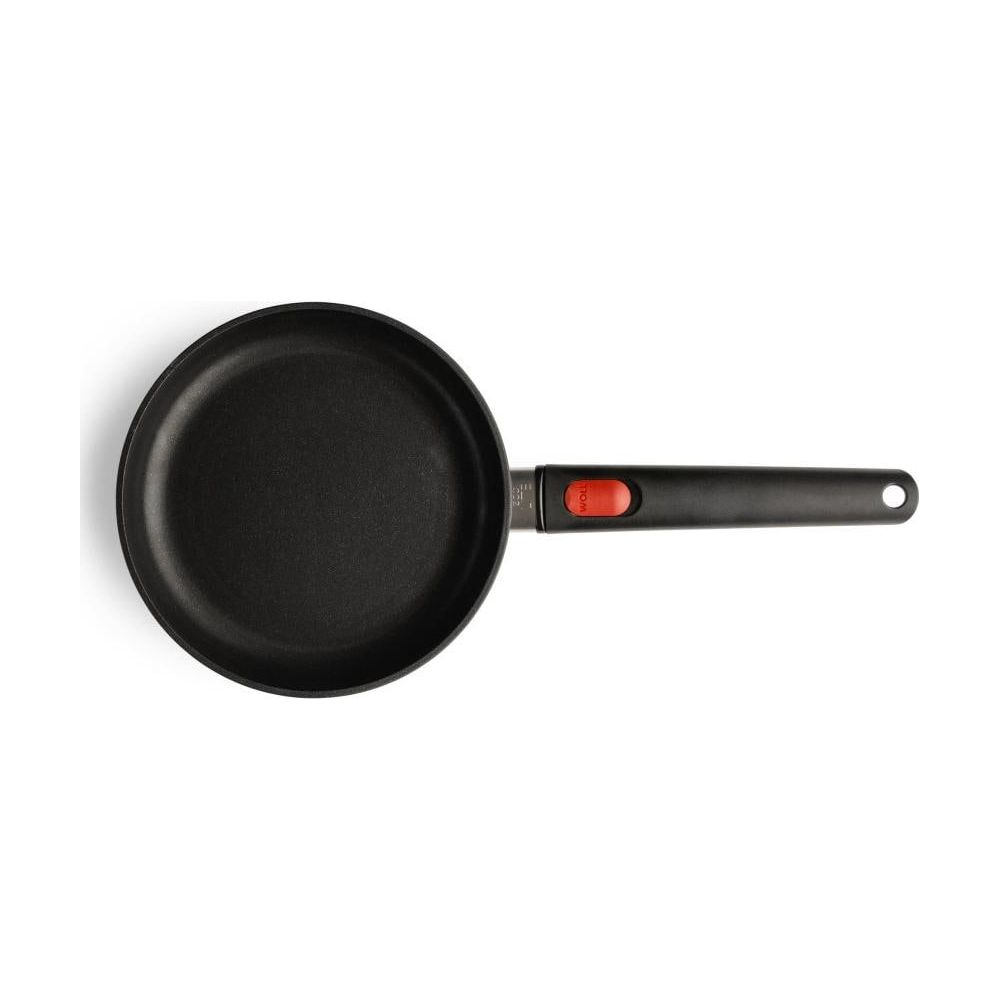 Schwarze Bratpfanne mit rotem Griff auf weißem Hintergrund.