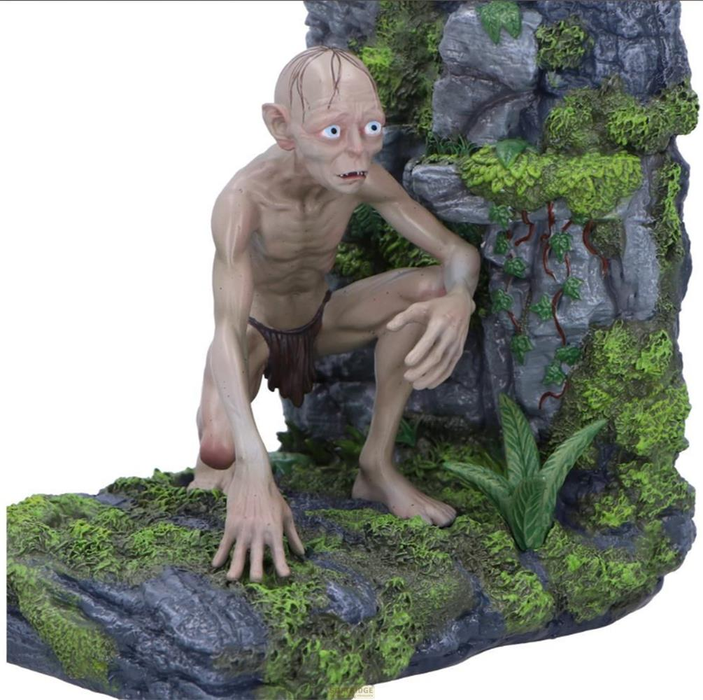 Eine Gollum-Figur kauert auf moosbewachsenen Felsen vor einer höhlenartigen Struktur.