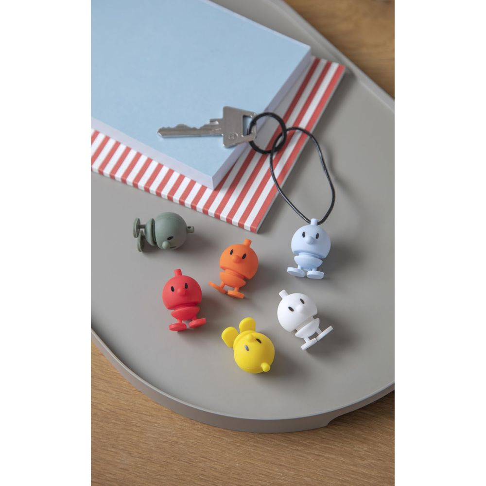 Seis figuras coloridas en una bandeja junto a un cuaderno y una llave.