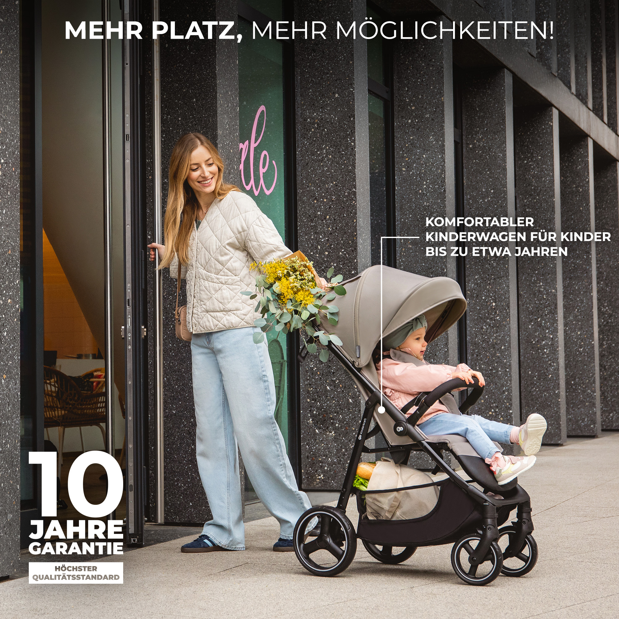 Eine Frau öffnet eine Tür, ein Kinderwagen mit Baby steht daneben.