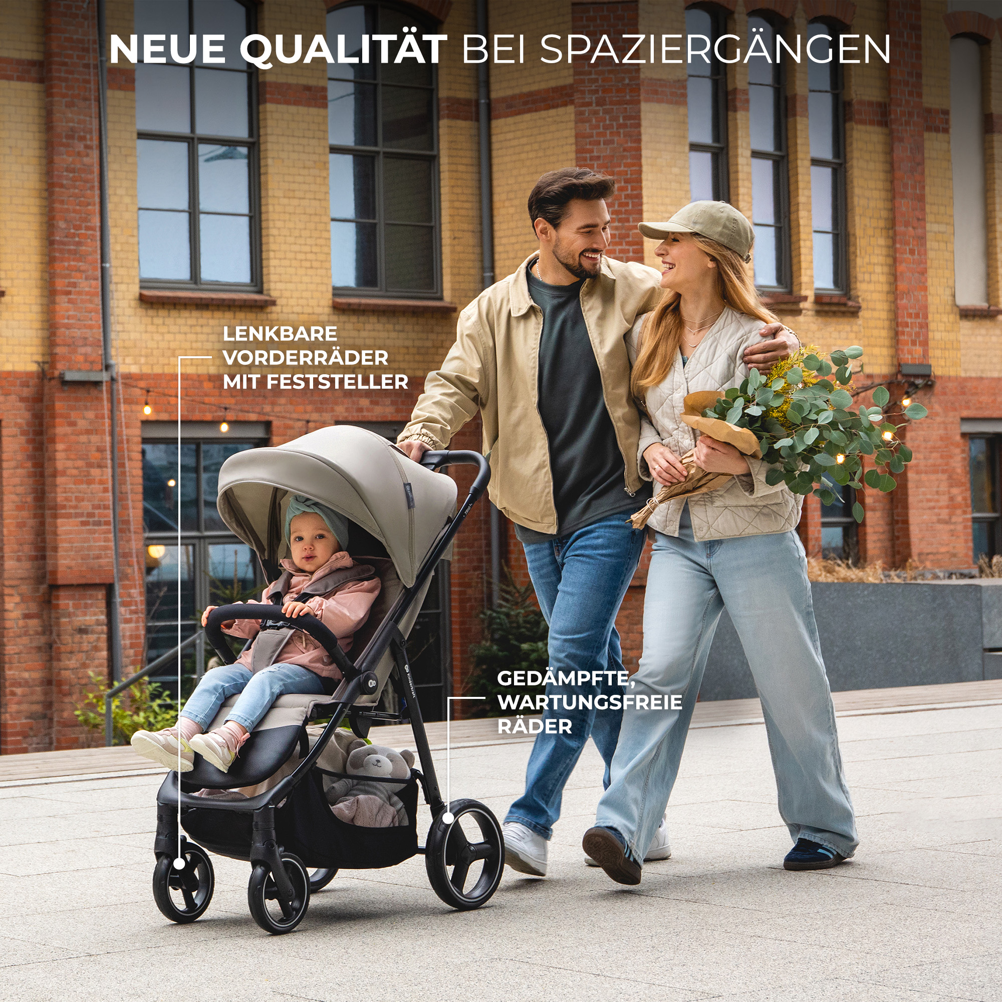 Ein Paar spaziert mit Kinderwagen und Blumenstrauß vor Backsteingebäude.