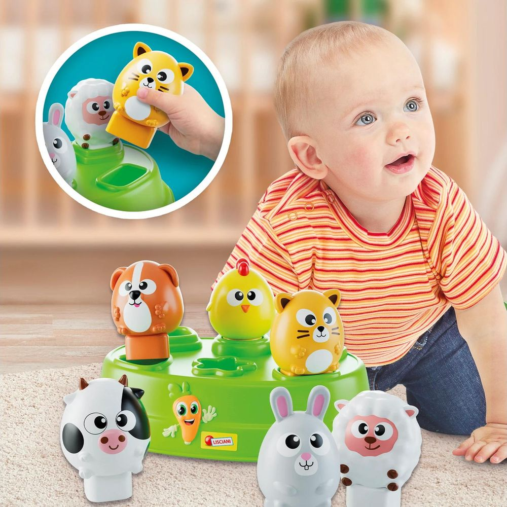 Ein Baby spielt mit einem bunten Bauernhof-Spielzeug mit Tierfiguren.