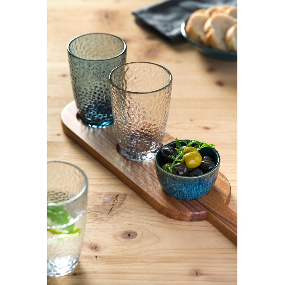 Drei strukturierte Gläser, eines mit Wasser und Minze, auf einem Holztablett mit Oliven.