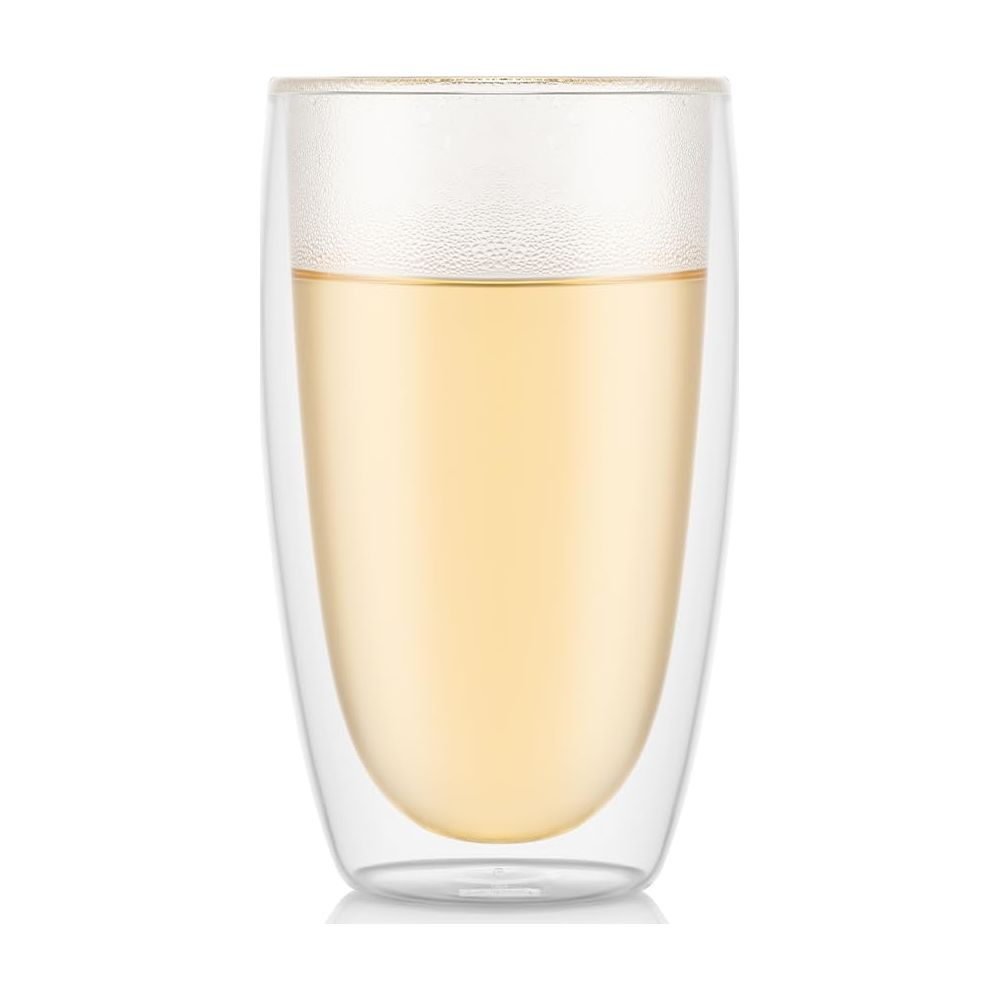 Ein klares doppelwandiges Glas, gefüllt mit gelber Flüssigkeit, wahrscheinlich Tee oder Saft.