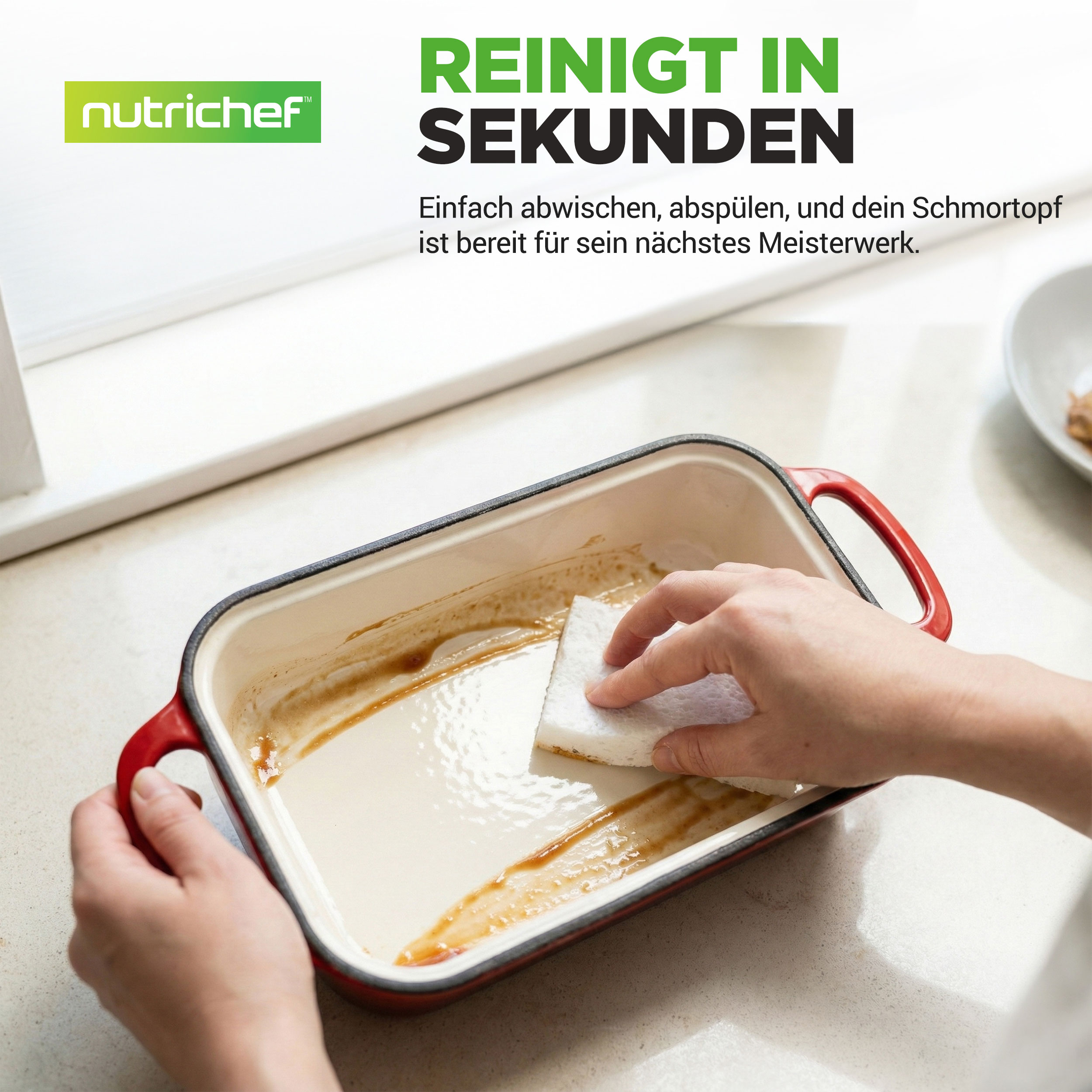 Eine Hand reinigt einen roten Bräter mit einem weißen Schwamm.