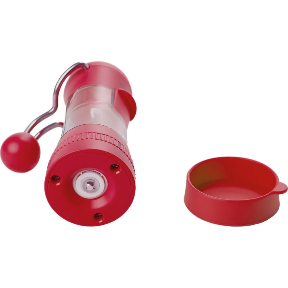 Eine rote Gewürzmühle mit silbernem Kurbelgriff und eine rote Schale.