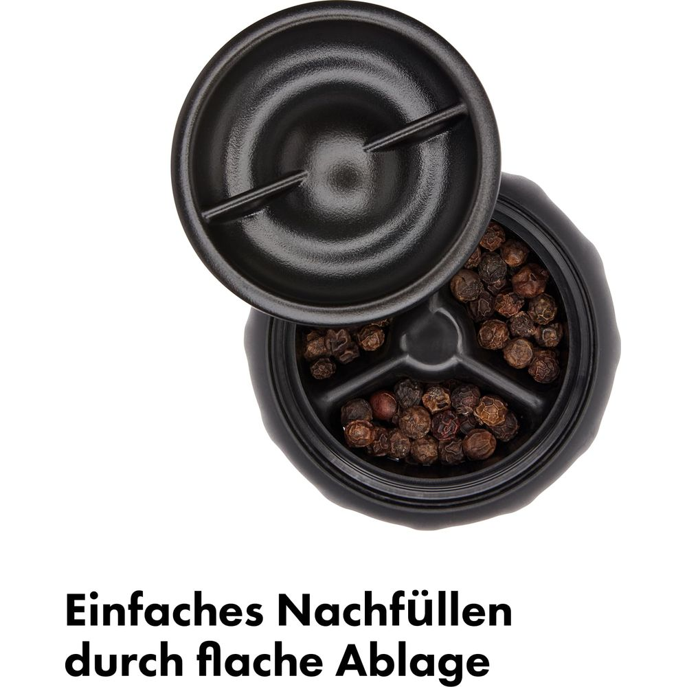Schwarze Pfefferkörner in einem schwarzen Behälter mit offenem Deckel.