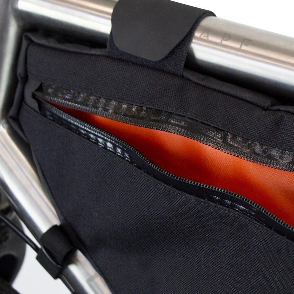 Schwarze Fahrradtasche mit offenem Reißverschluss und orangefarbenem Innenfutter.