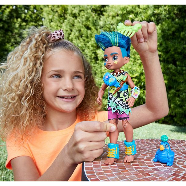 Ein Mädchen spielt mit einer Puppe mit blauen Haaren. Ein kleiner blauer Spielzeugvogel ist in der Nähe.