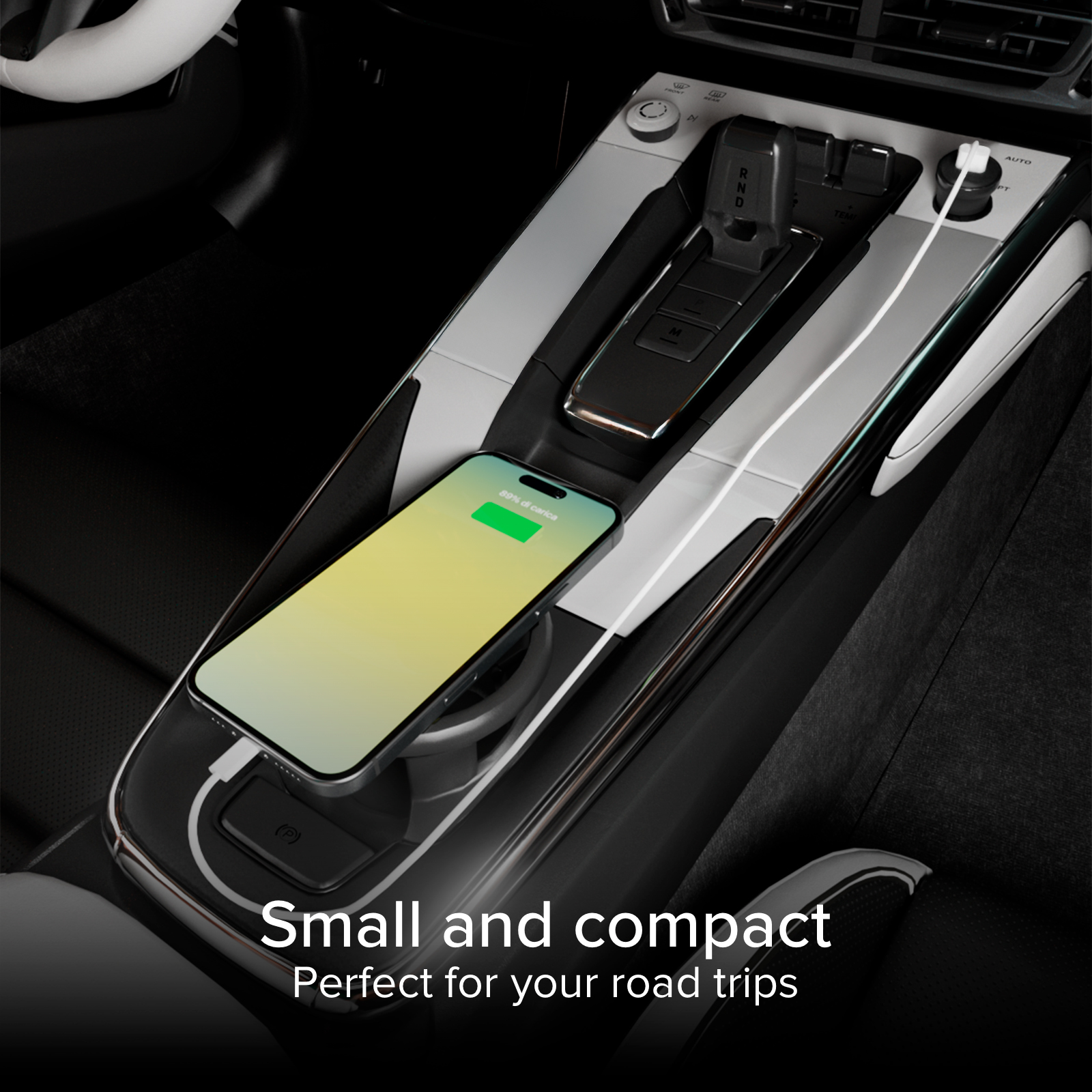 Ein Smartphone lädt in der Mittelkonsole eines Autos. Text: Klein und kompakt.