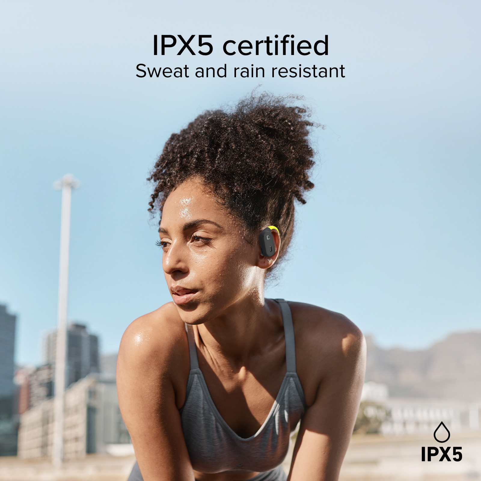 Una donna sudata con auricolari all'aperto, certificata IPX5.