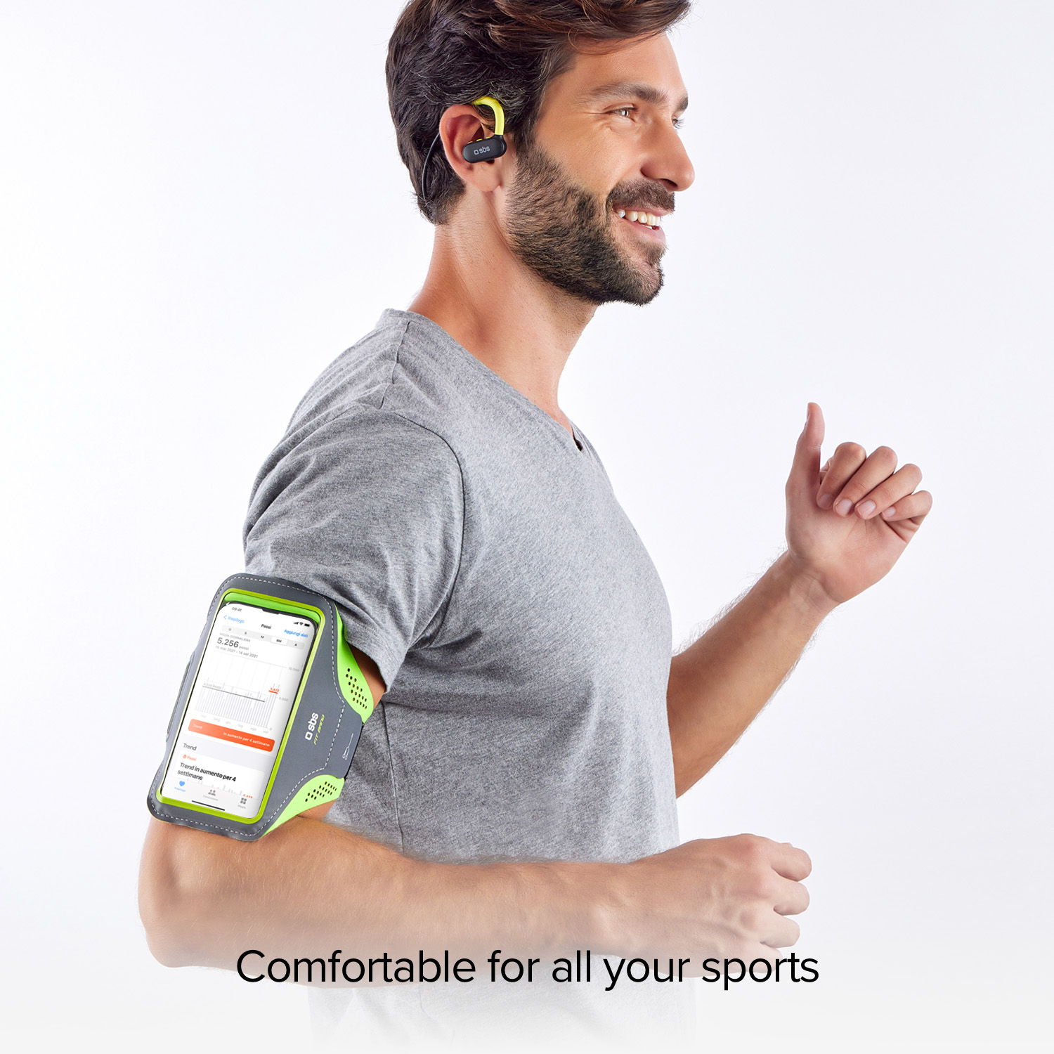 Hombre con soporte de teléfono en el brazo y auriculares, sonriendo.