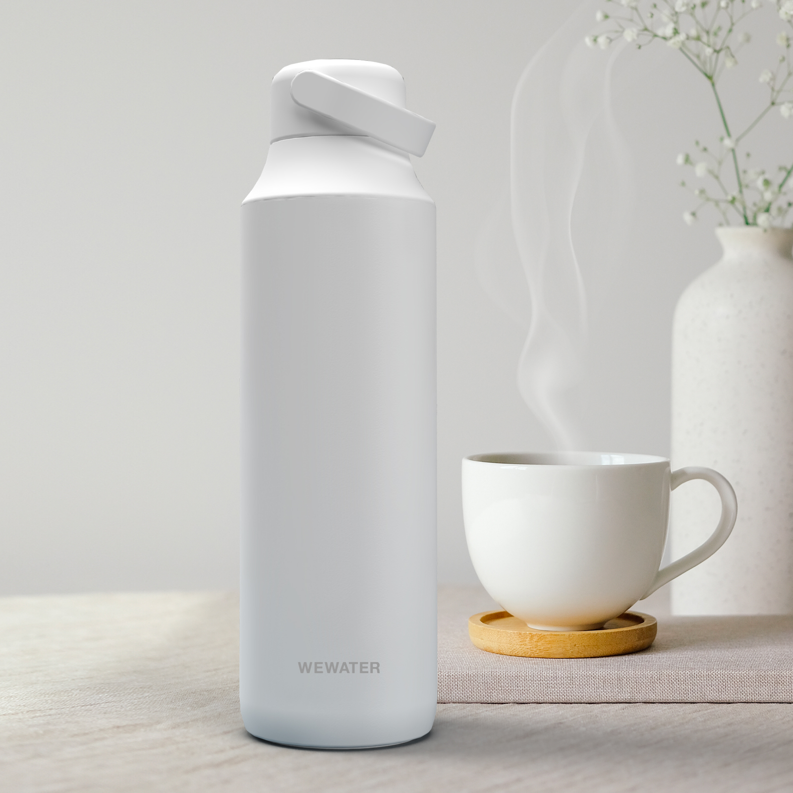 Un termo blanco junto a una taza de café humeante sobre una mesa de madera.