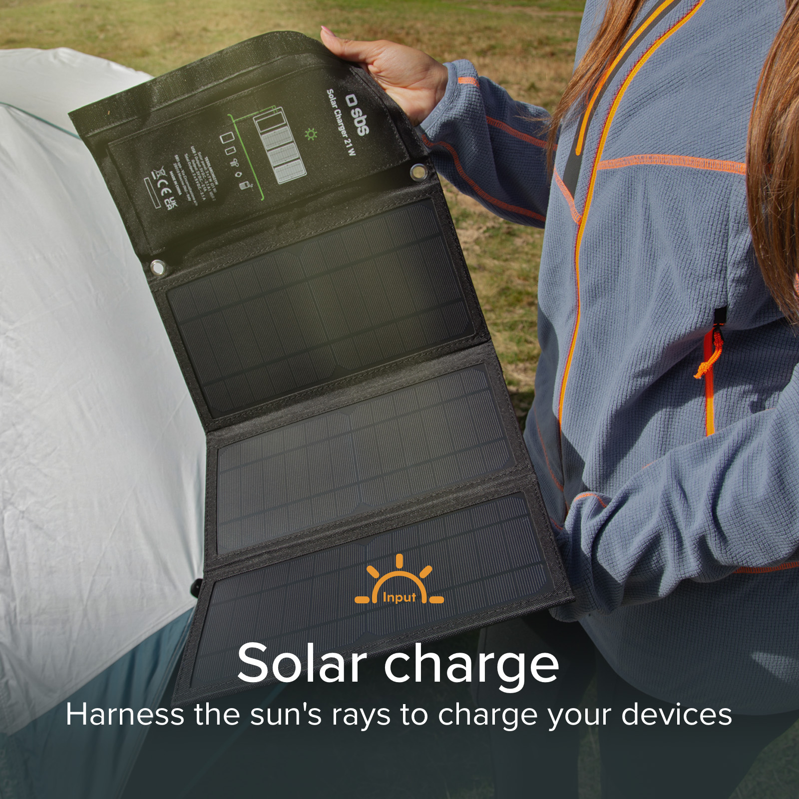 Una persona tiene un pannello solare aperto con l'etichetta 'Solar charge'.
