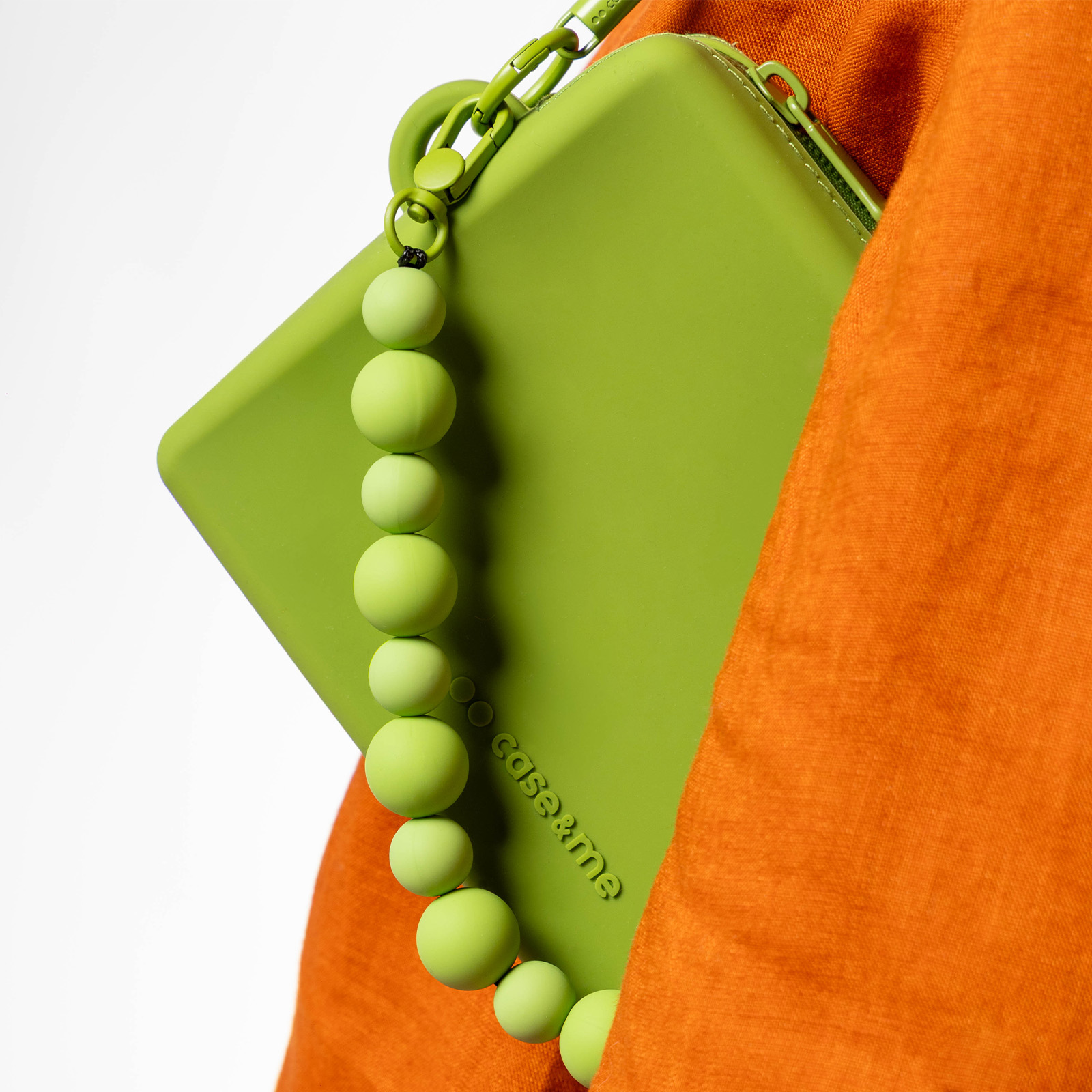 Bolso verde con correa de perlas, tela naranja. Logo: case&me.