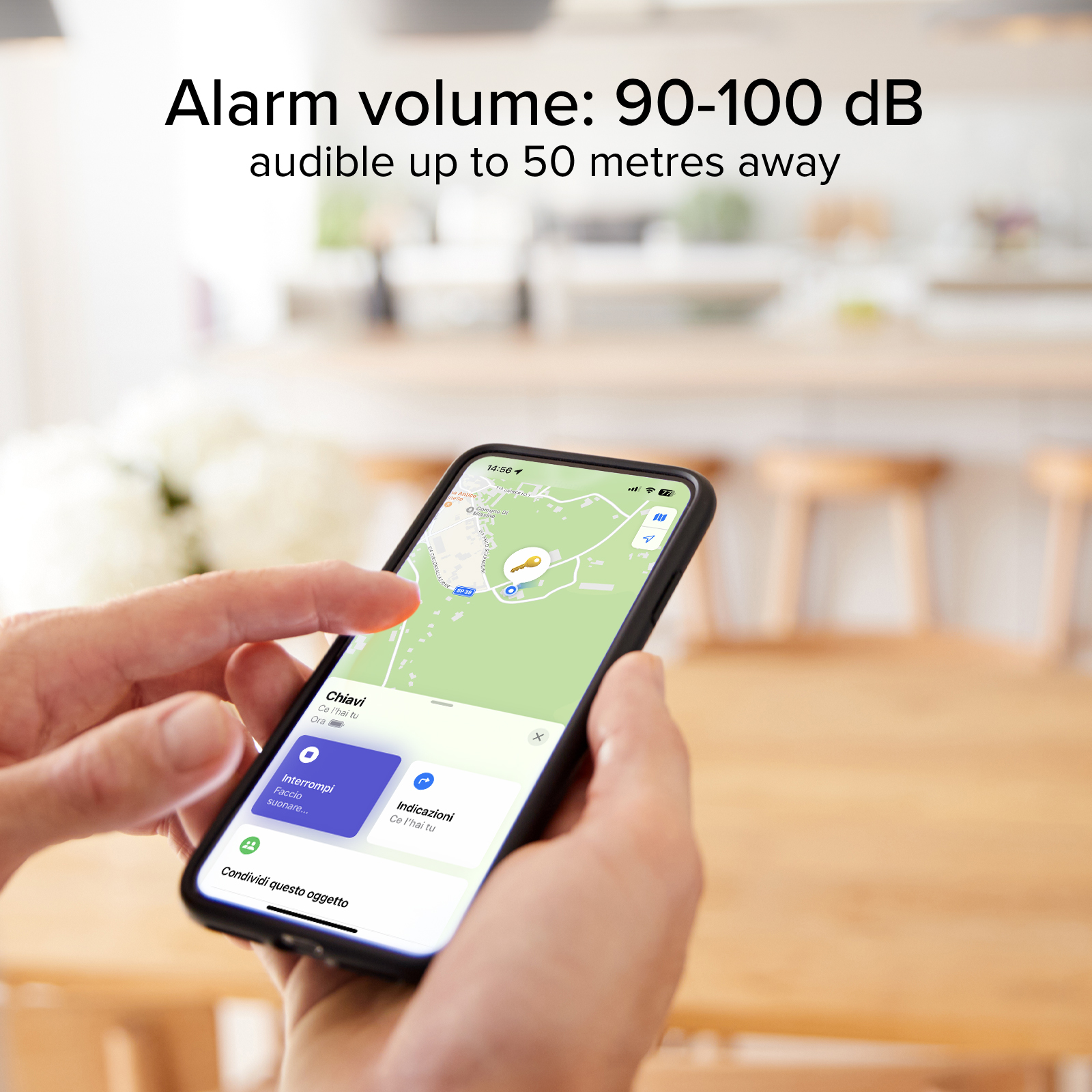Una mano sostiene un smartphone mostrando un mapa con un icono de llave, el texto dice "Volumen de alarma: 90-100 dB".