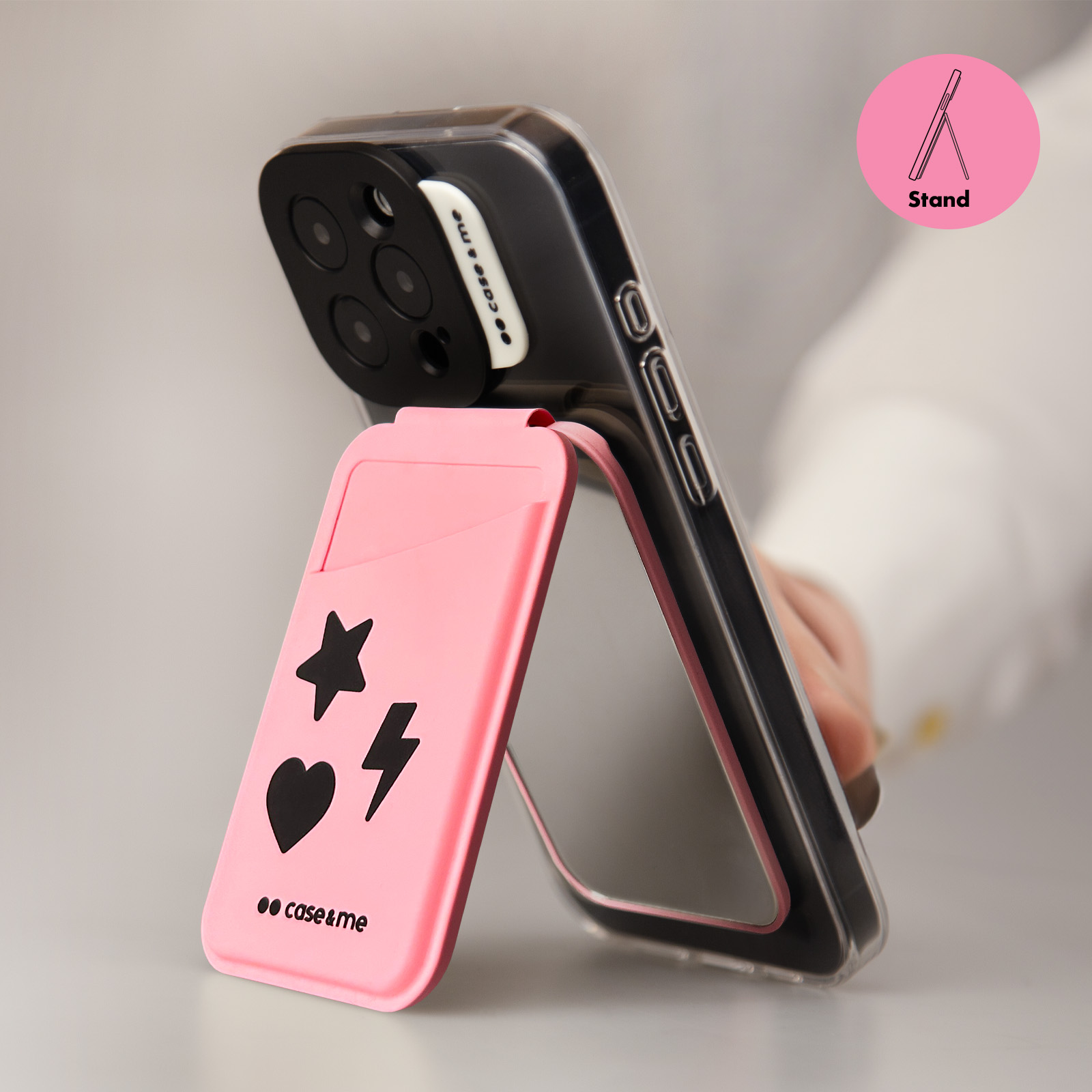 Una funda rosa para teléfono con iconos de estrella, corazón y rayo se mantiene vertical.