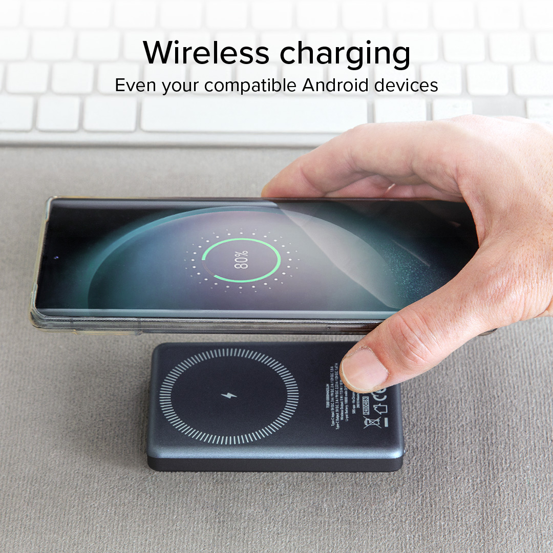 Un teléfono se carga inalámbricamente en una base de carga negra, mostrando 80%.