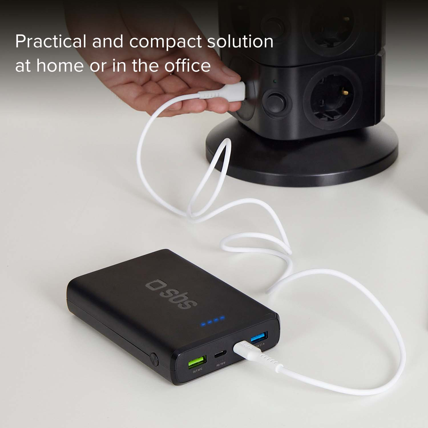 Un power bank nero è collegato a una ciabatta nera.