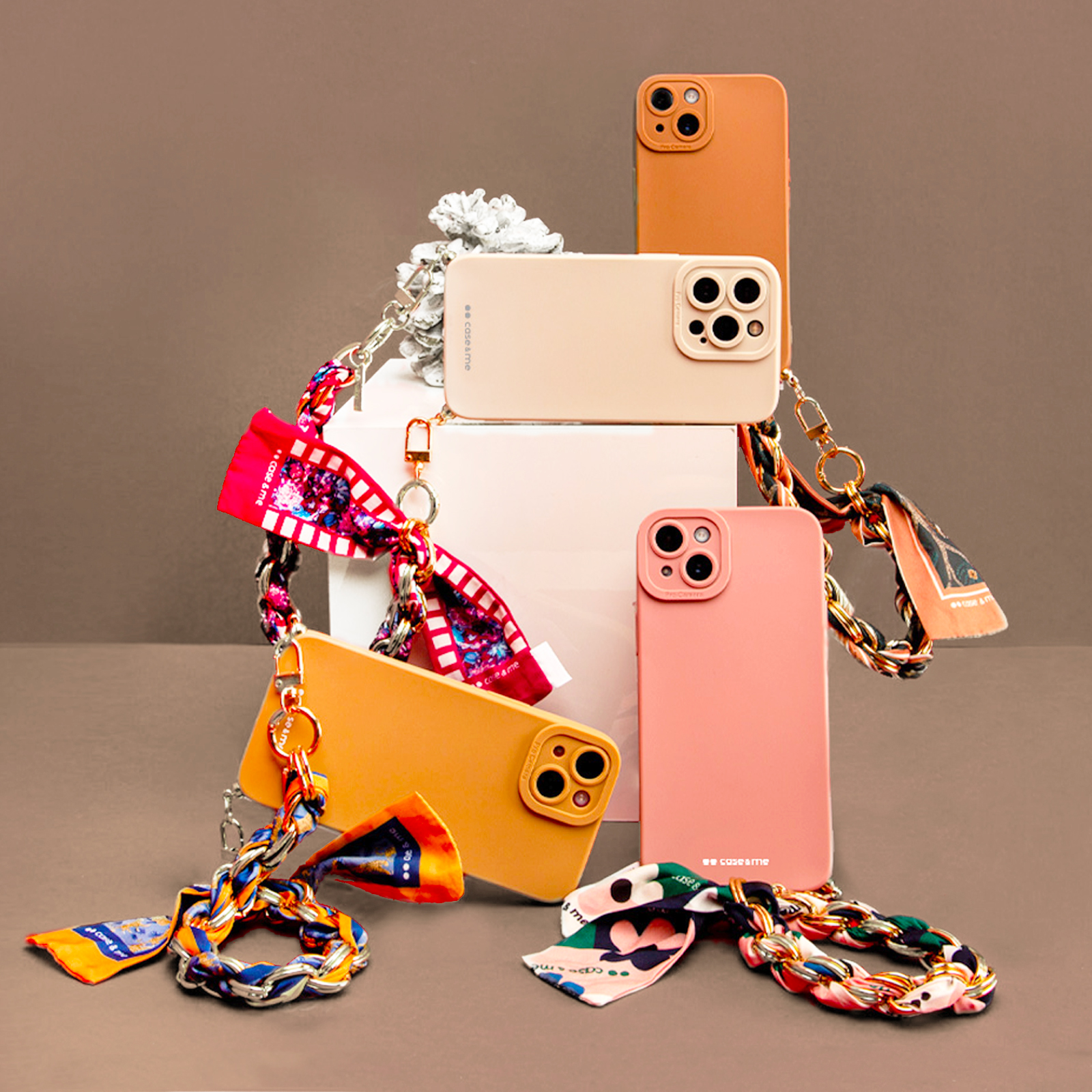 Cuatro fundas de teléfono en varios colores con correas de cadena y pañuelos.