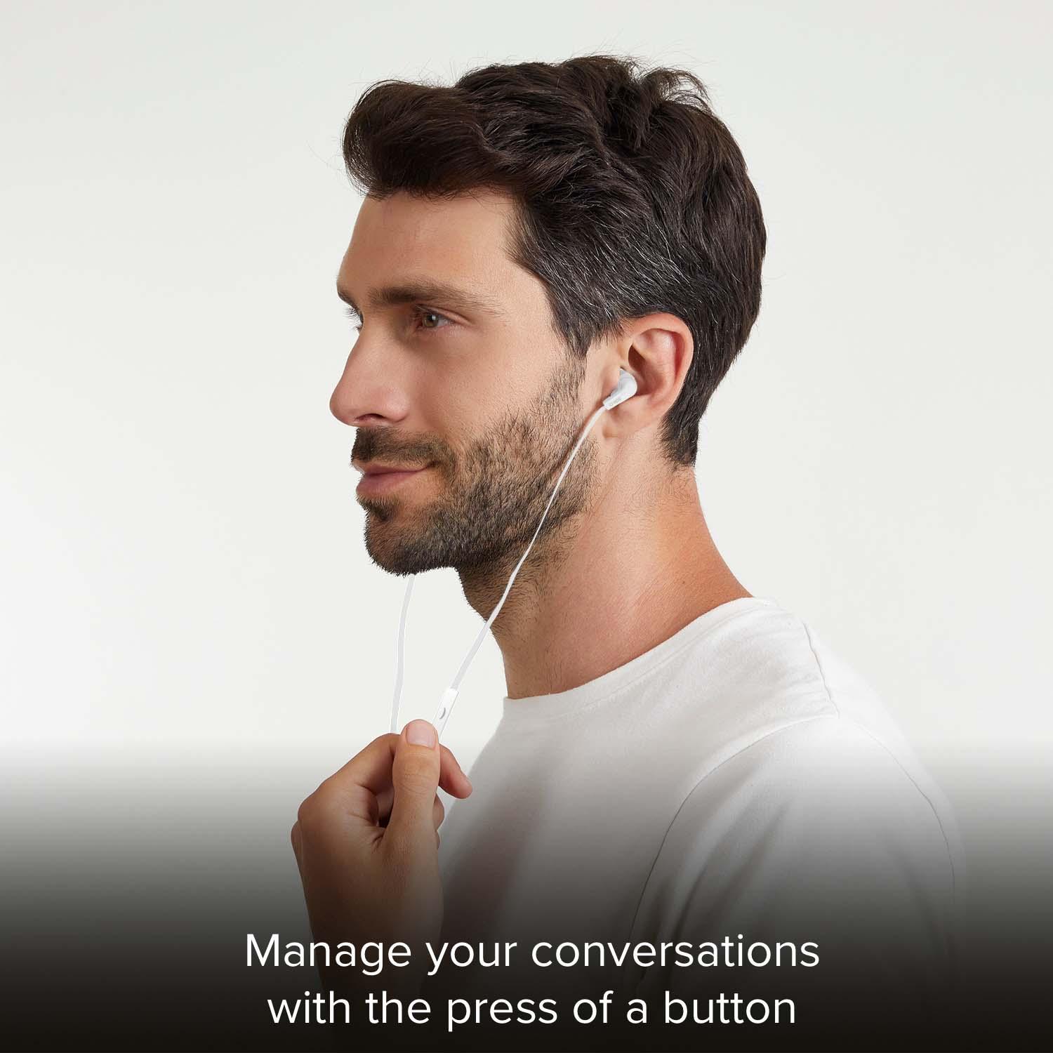 Hombre con auriculares blancos, presionando un botón.