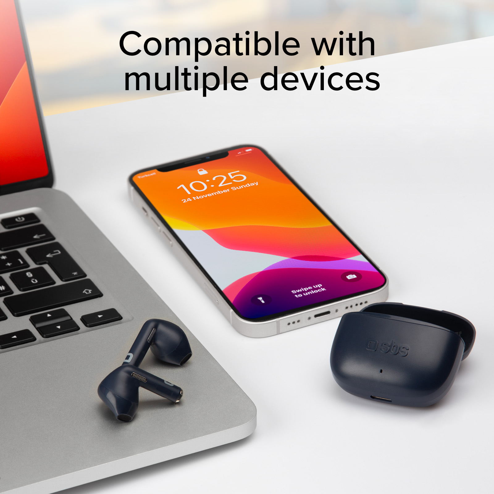 Ein Laptop, ein Smartphone und kabellose Ohrhörer liegen auf einem Schreibtisch.
