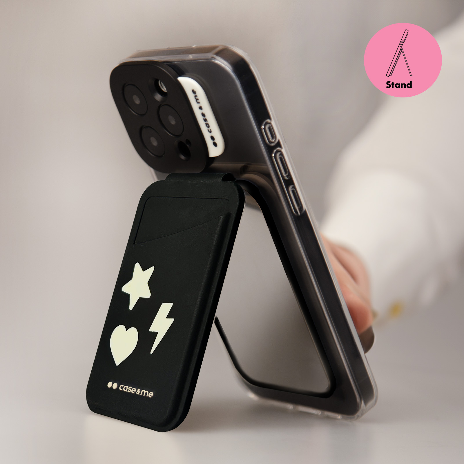 Una funda de teléfono transparente con soporte negro con iconos blancos de estrellas, corazón y rayo.