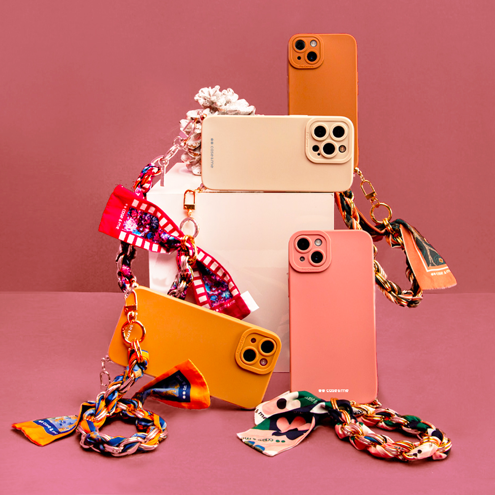 Cuatro fundas de teléfono en diferentes colores con correas de cadena y pañuelos.