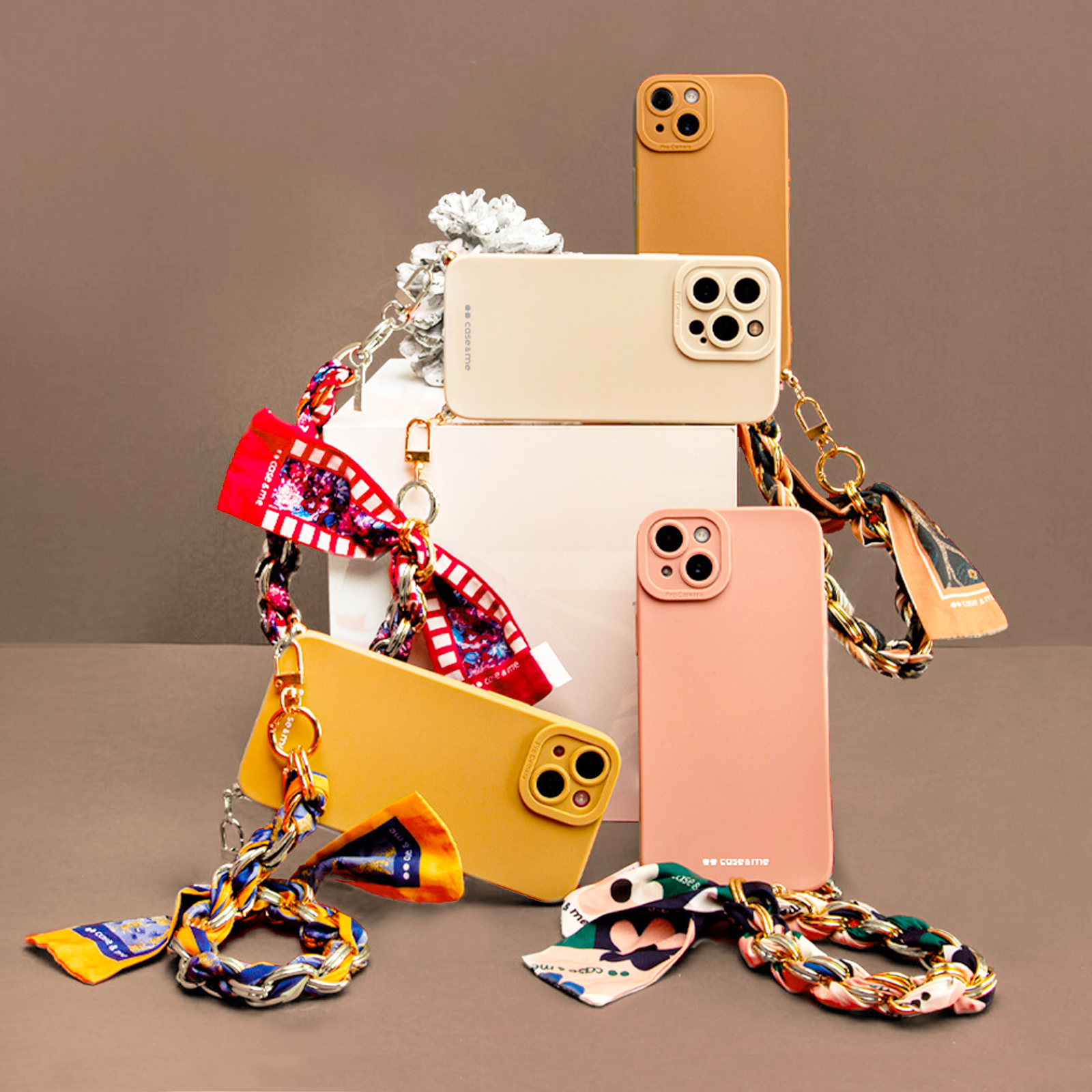 Quattro custodie per telefono con lacci colorati a nastro su sfondo marrone.