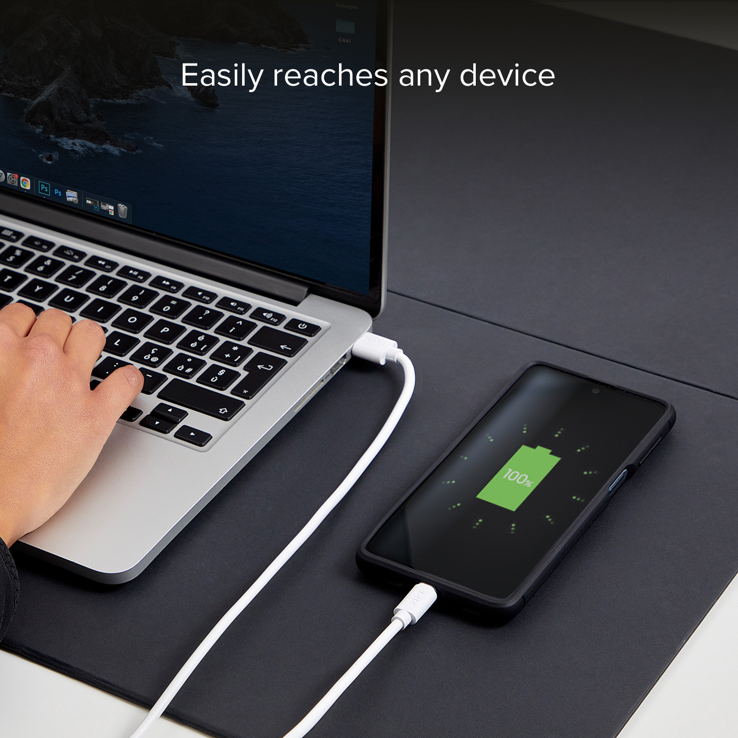 Un portátil y un smartphone conectados por cables blancos sobre superficie negra.
