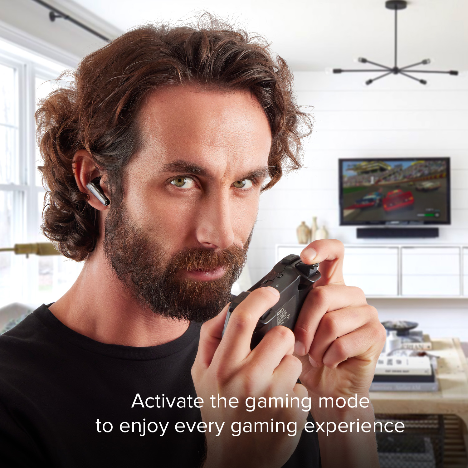 Uomo con auricolare gioca ai videogiochi con controller davanti alla TV.