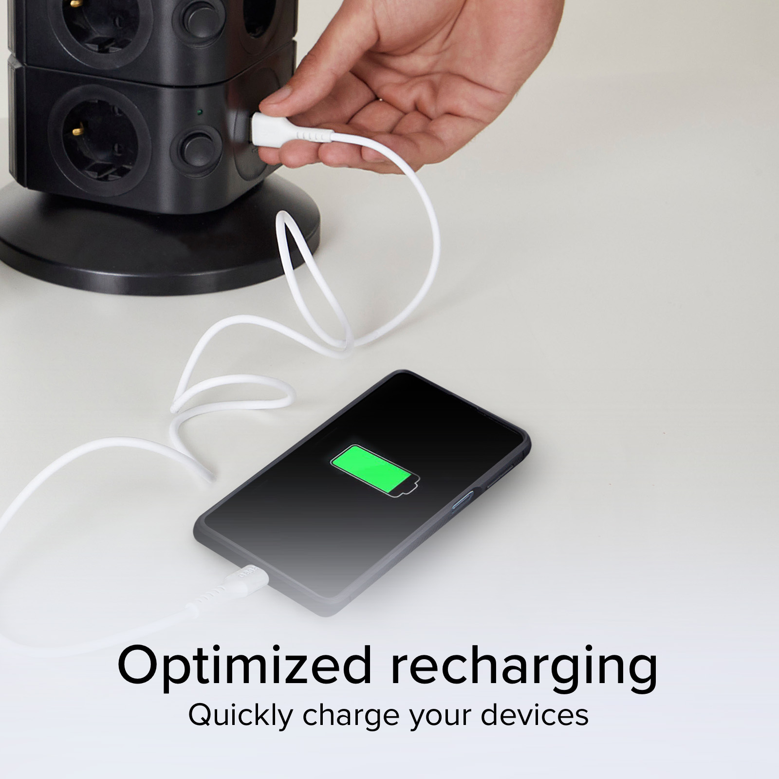 Un téléphone avec une batterie verte est branché à une multiprise noire.