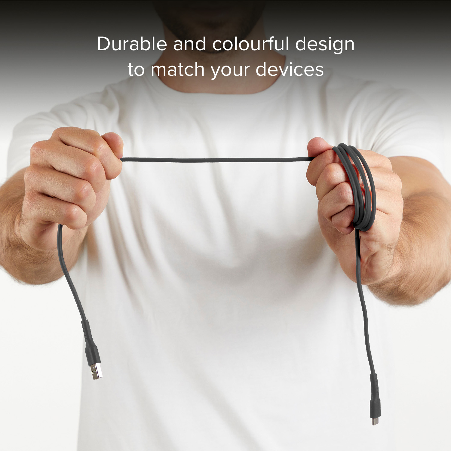 Man in white t-shirt holds black USB cable with both hands.