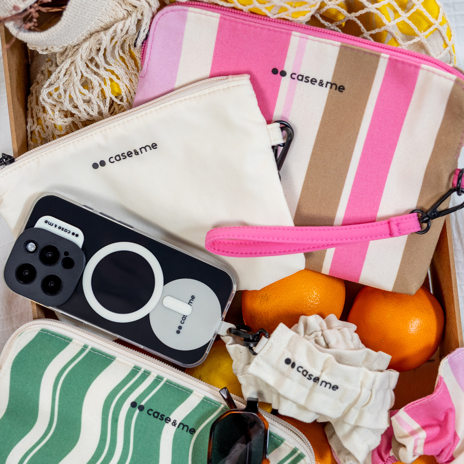 Un teléfono con funda descansa sobre bolsas a rayas, naranjas y redes.