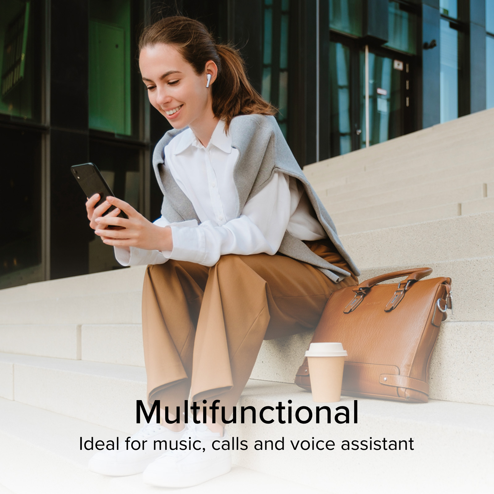 Una donna seduta sulle scale, ascolta musica e guarda il telefono.