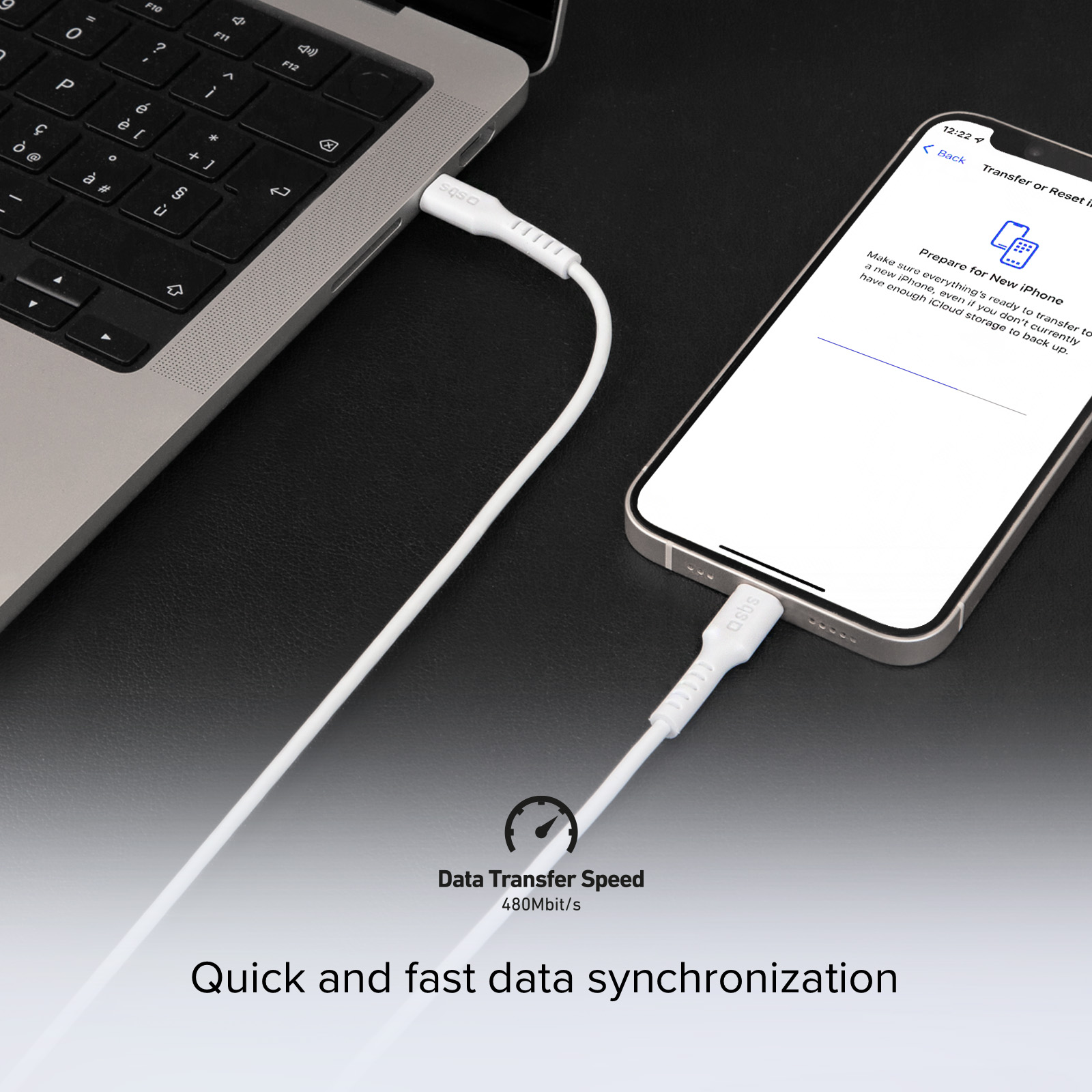 Un câble blanc relie un MacBook à un iPhone pour le transfert de données.