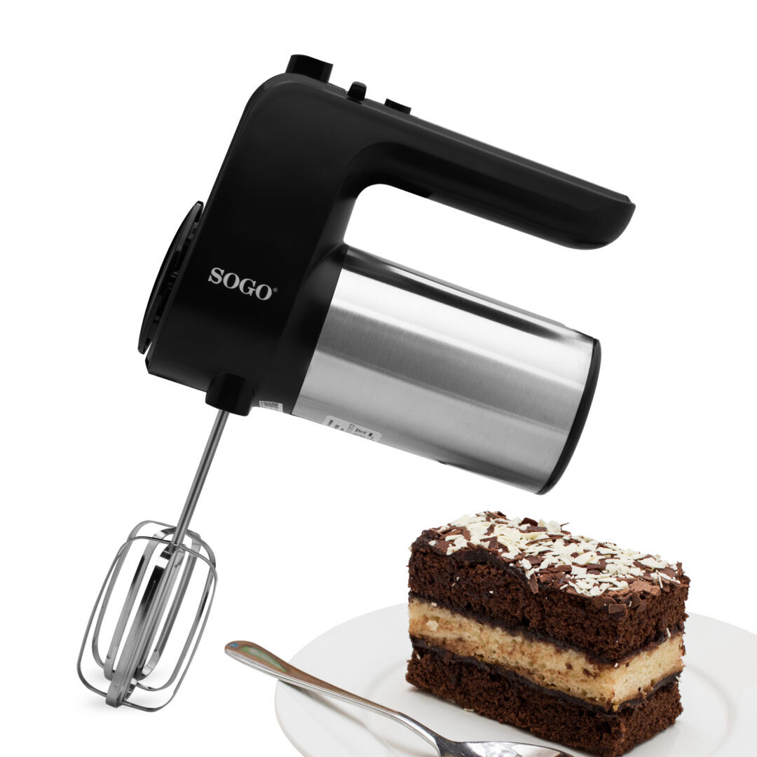 Un frullatore a mano SOGO nero e argento con frusta è inclinato sopra una fetta di torta al cioccolato con codette bianche su un piatto bianco con un cucchiaio.
