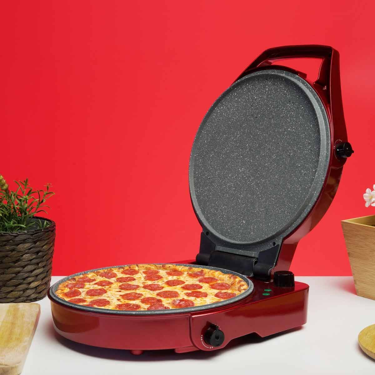 Una máquina para pizza roja con tapa abierta, que muestra una pizza de pepperoni terminada.