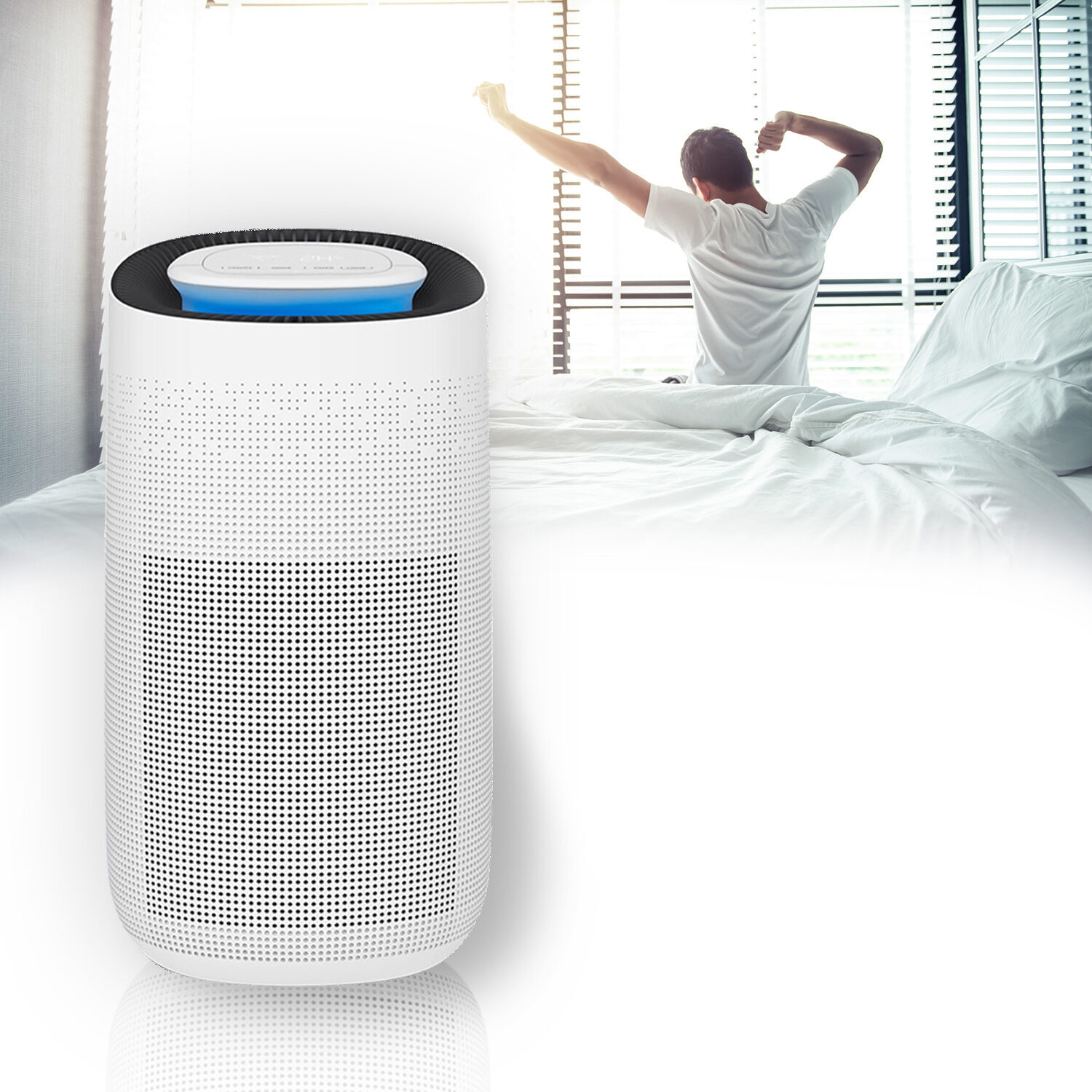 Un purificatore d'aria bianco su un letto, un uomo si stira.