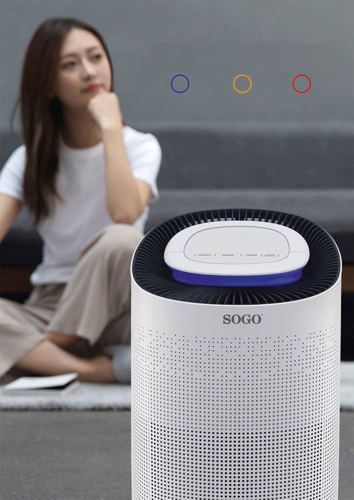 Una donna seduta davanti a un purificatore d'aria Sogo bianco.