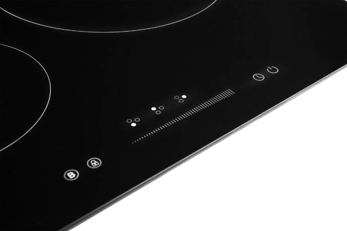 Primo piano di un piano cottura a induzione nero con controlli touch.