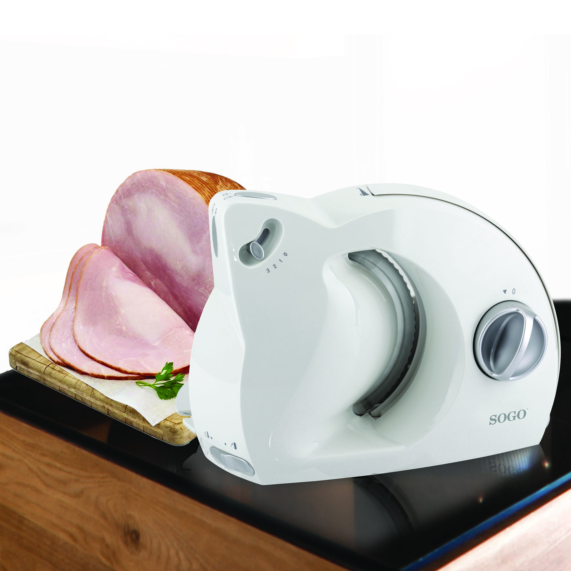Un'affettatrice bianca con prosciutto affettato su un tagliere di legno.