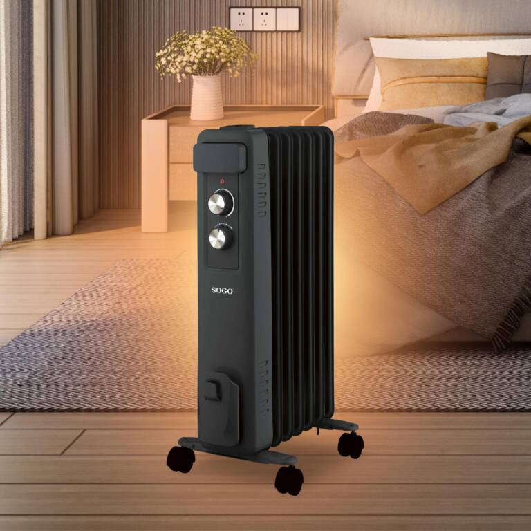 Termoventilatore nero a olio con ruote accanto a un comodino con fiori.