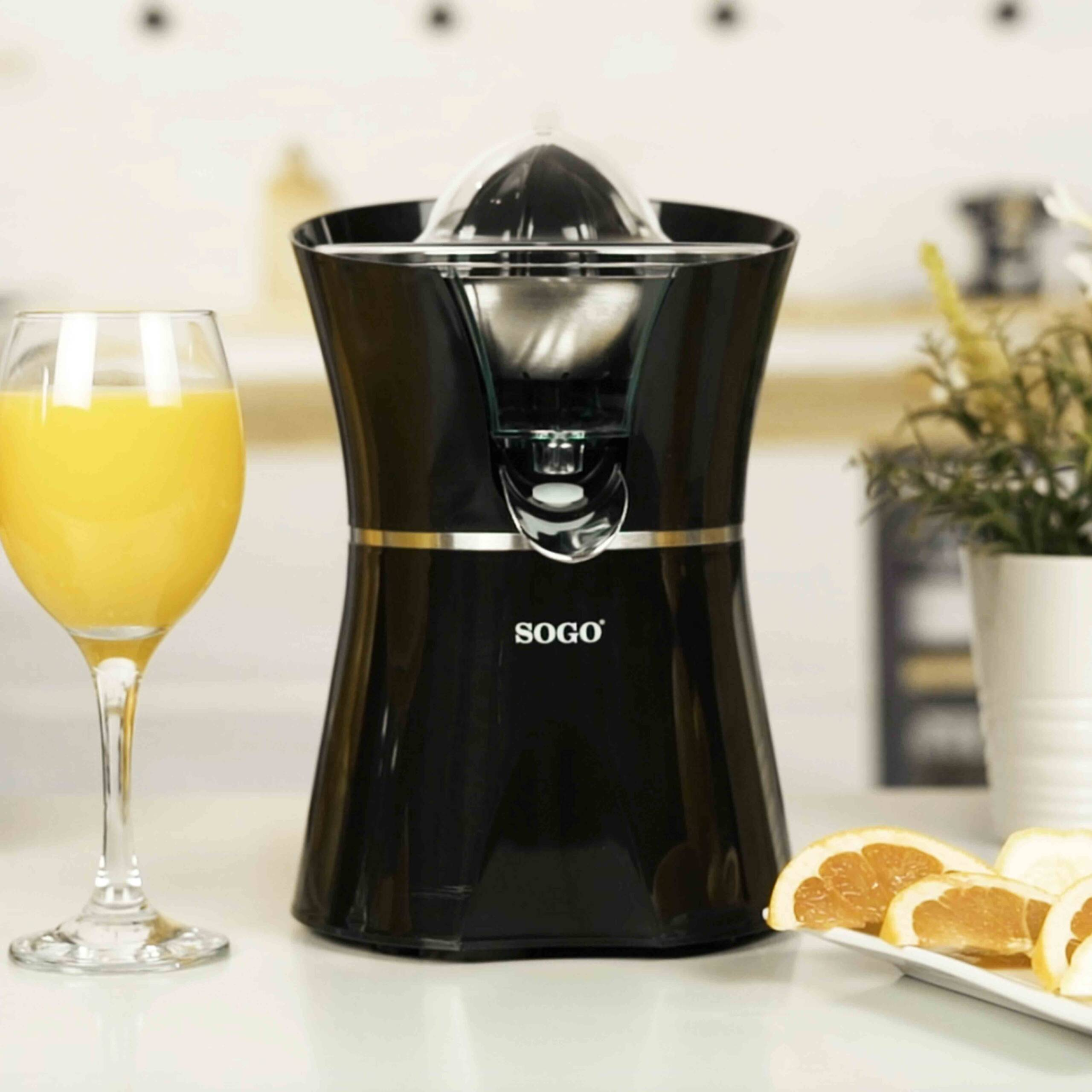 Spremiagrumi SOGO nero con un bicchiere di succo d'arancia e arance a fette.