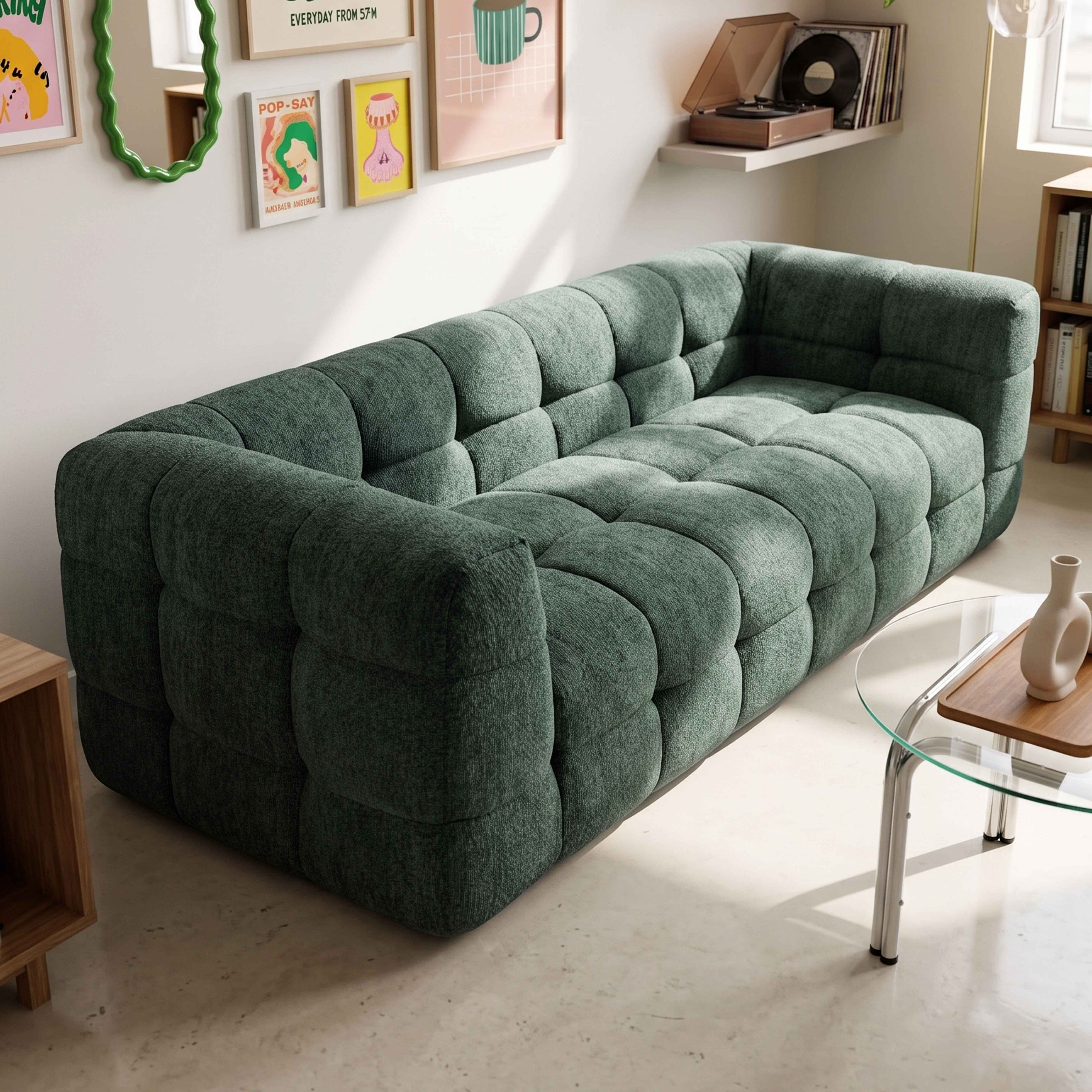 Ein tiefgrünes, gepolstertes Sofa mit karierten Mustern steht in einem hellen Raum mit Kunst an der Wand.